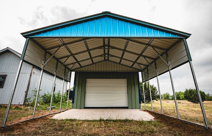 Vertical style roof metal carport sheltering red pickup truck and boat on trailer