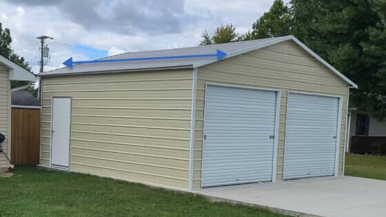 A beige 2-car metal garage with a boxed-eave roof