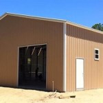 A tan metal building with one garage door and one walk-in door