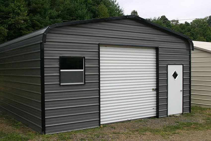 A gray metal shed with white doors