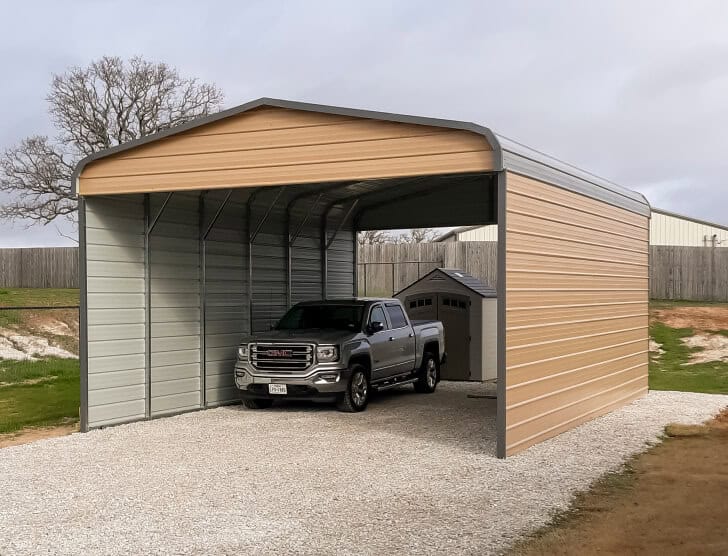 Two-car carport covering a pickup truck placed on a gravel foundation.