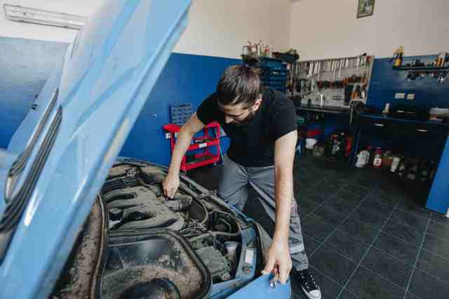 man working on car in garage