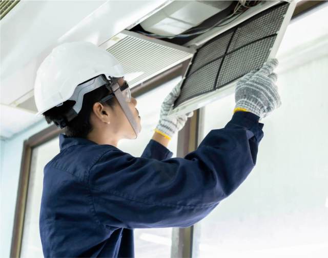 Technician cleaning air filter