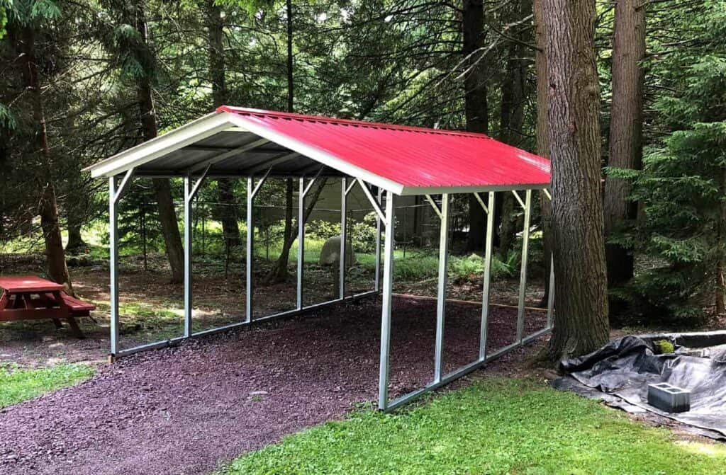 metal carport with a red roof next to a tree