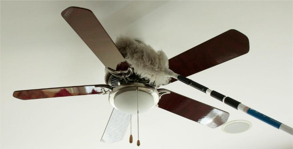 Dusting a ceiling fan with an extended duster