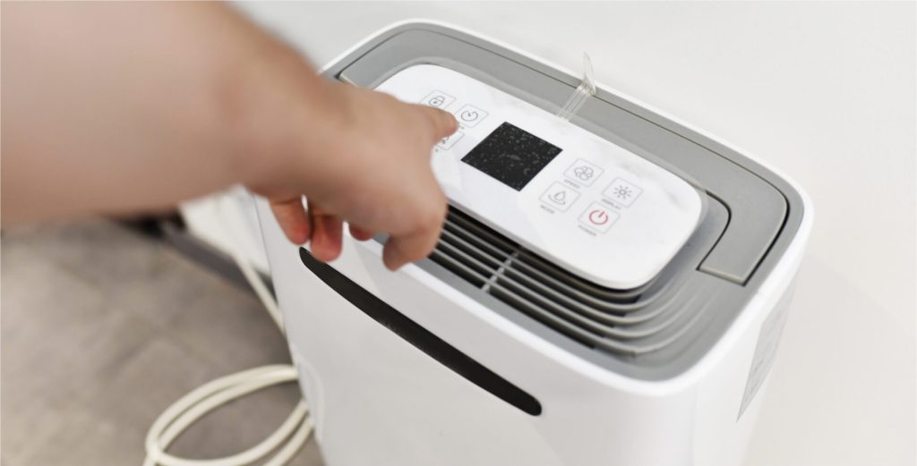 Person adjusting dehumidifier settings