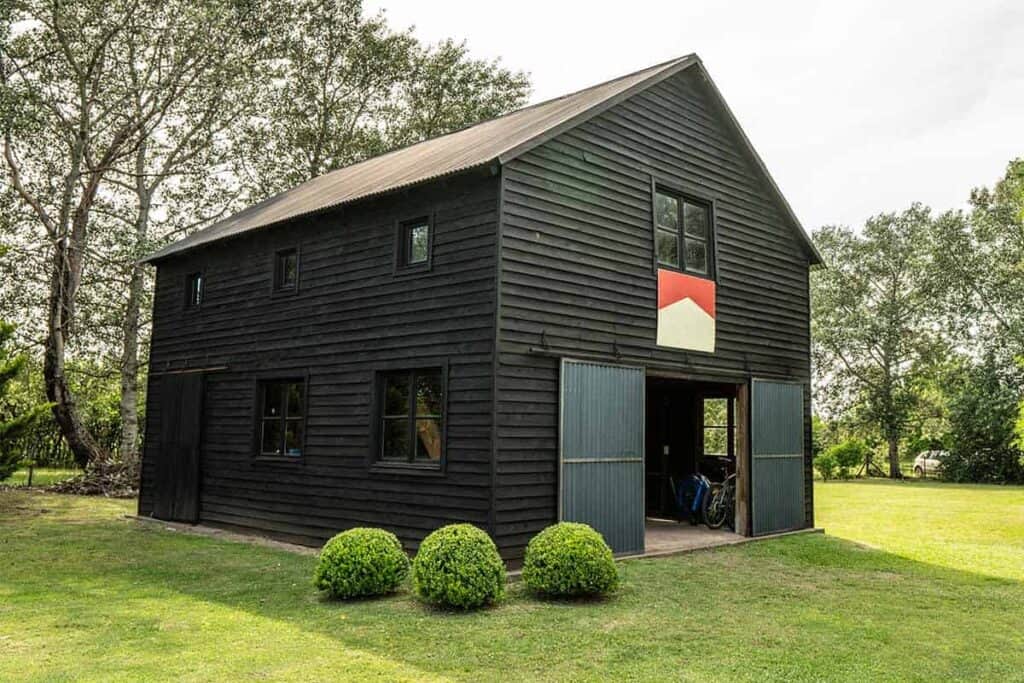 brown barndominium with front lawn