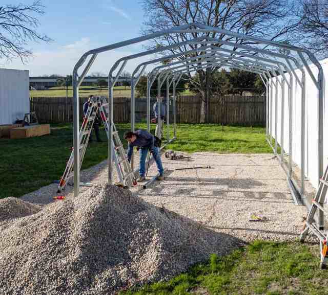 builders adding gravel foundation to carport structure