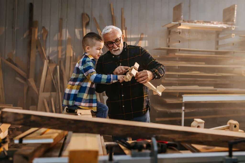 elderly man with grandson in garage workshop