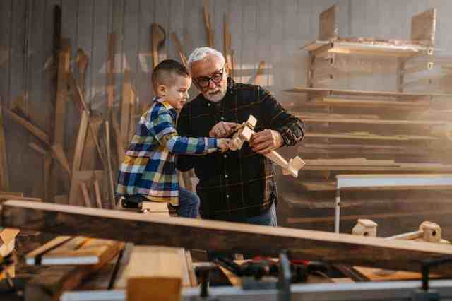 elderly man with grandson in garage workshop