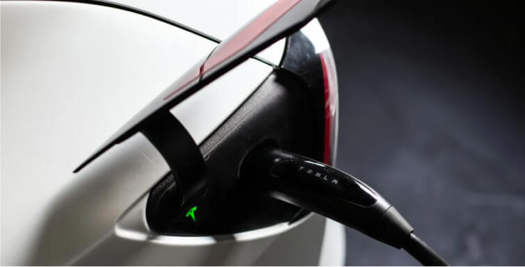 Close-up of a Tesla charging port with a connected charging cable