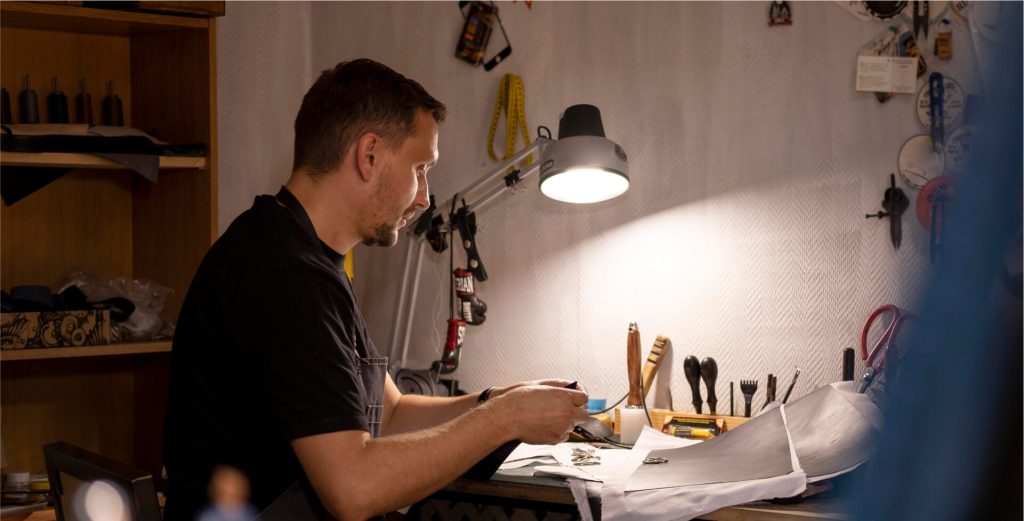 Craftsman working at a desk with a lamp