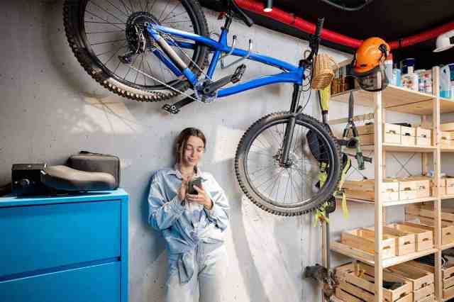 woman next to mounted bike in a garage