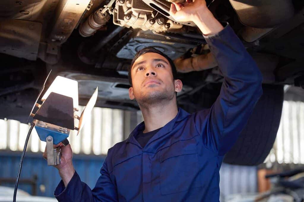 car mechanic using light in garage workshop