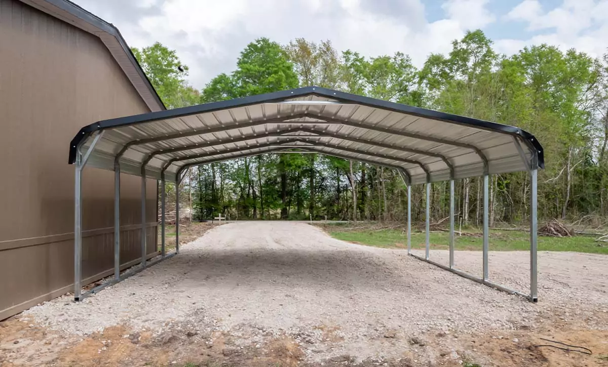 A carport is open on both ends with a grave drive through the middle.