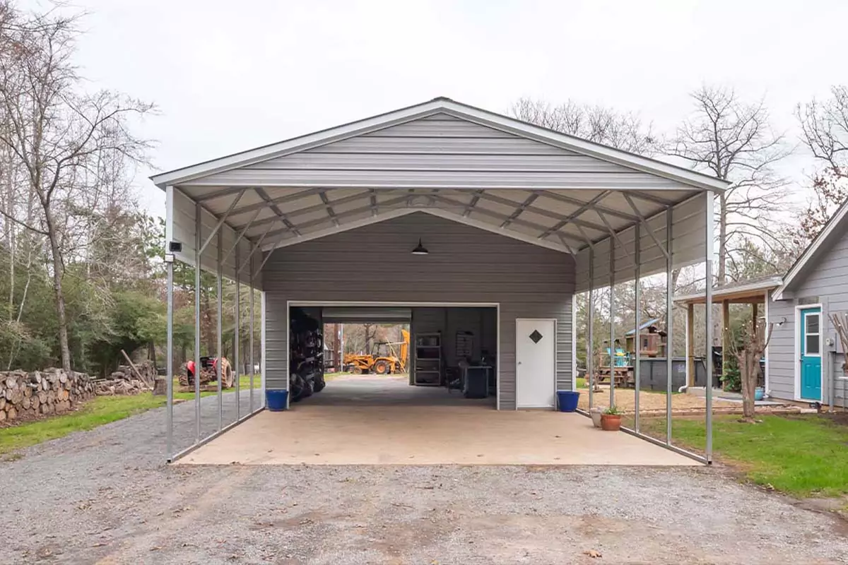 A drive through garage leads into the backyard and features a carport in front.