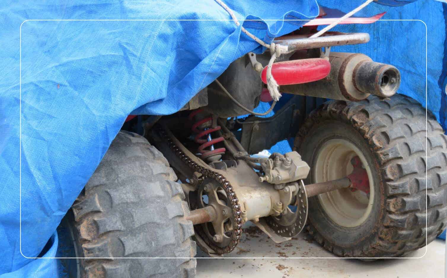 An image of an ATV beneath a blue tarp.
