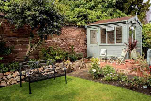 green backyard shed with great landscaping