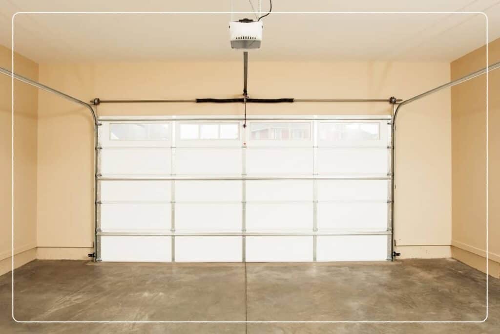 A closed garage door with an empty garage