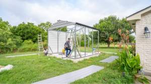 Metal garage frame being assembled by workers