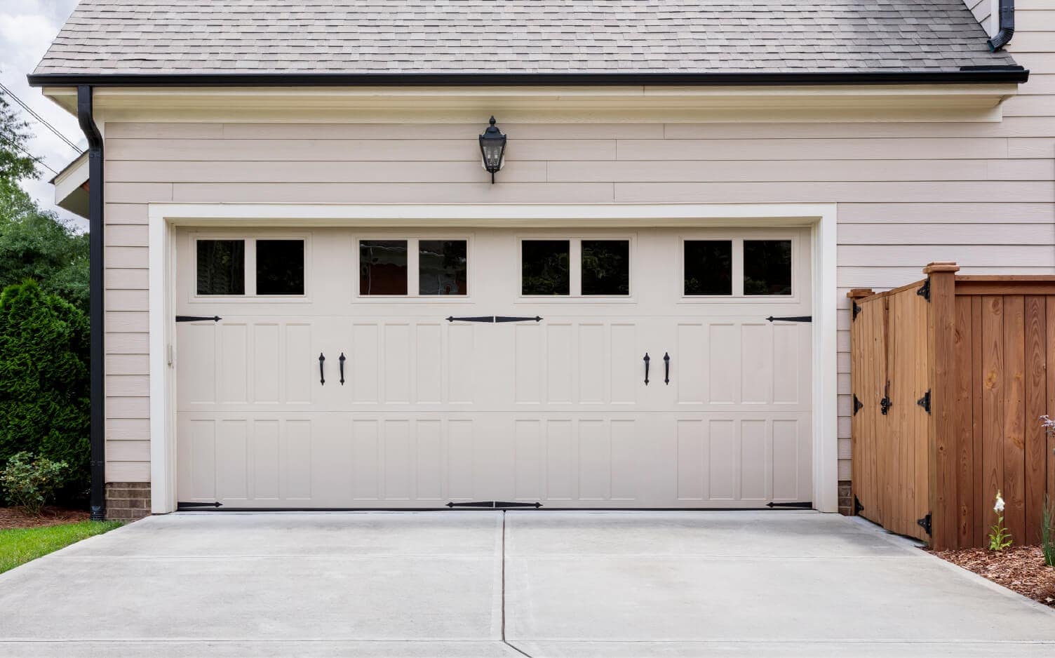 Photo of a two-car attached garage with white vinyl siding.