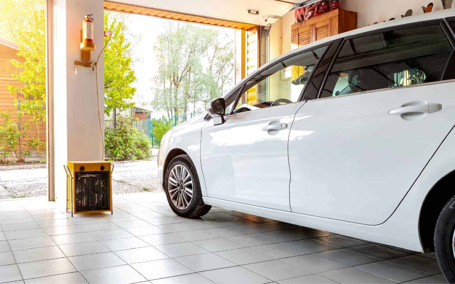 Photo of a white minivan parked in a two-car garage with doors open.