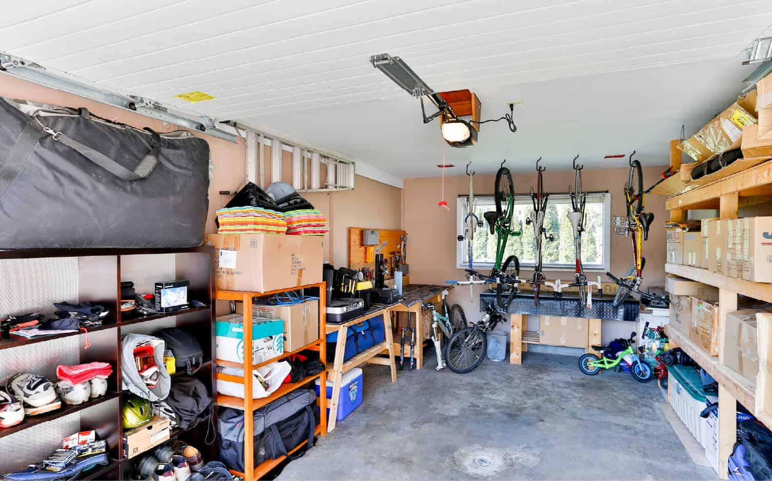 Interior photo of a garage with storage shelves, hanging bikes, and boxes.