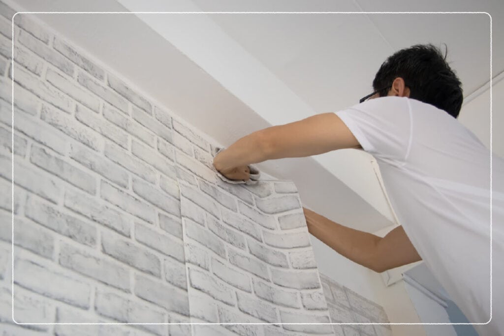 man installing wallpaper to garage wall