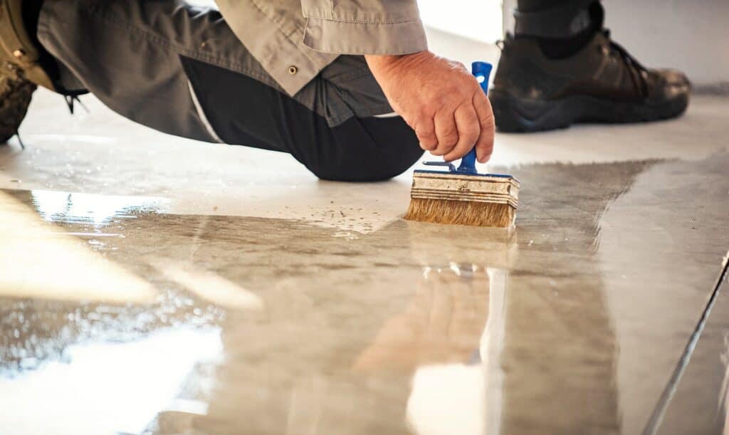 person applying a floor coating sealant