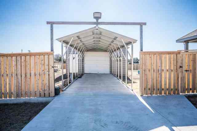 outside view of metal carport in front of a garage