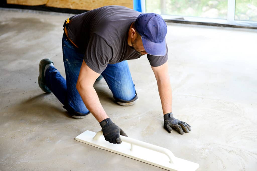 man repairing concrete garage floor