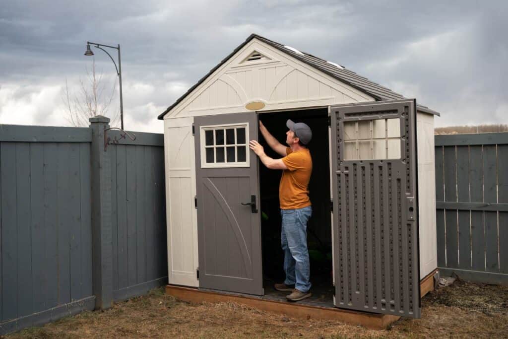 man disassembling a plastic shed