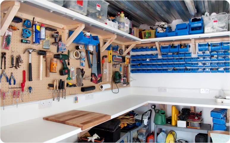 Workshop with workbench, tools hanging on pegboard, and shelving containing other items