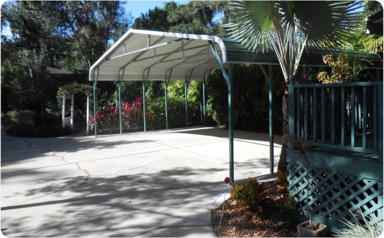 A large metal carport in the middle of a beautiful outdoor area