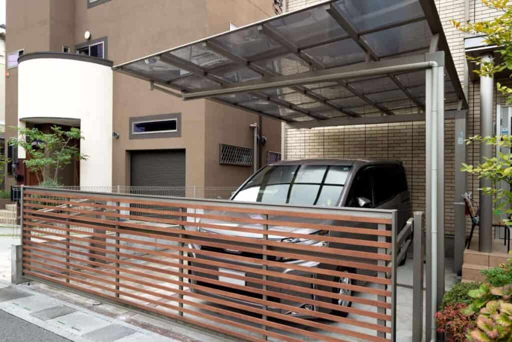 metal carport in driveway with an attached gate