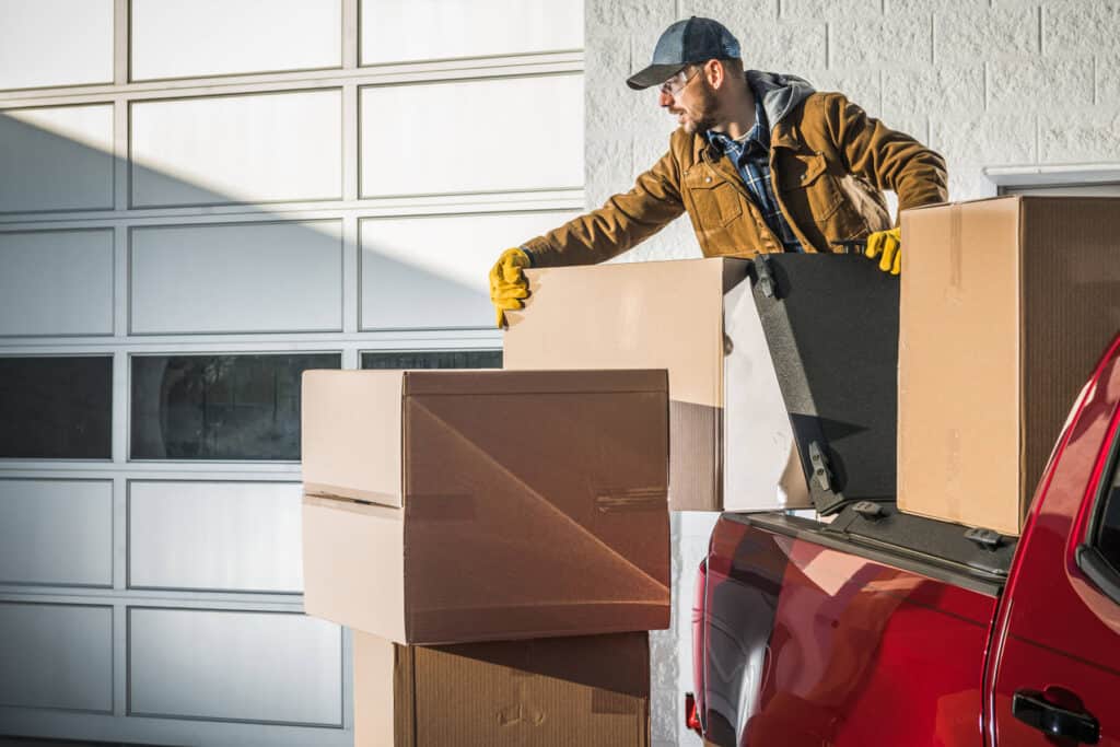A man loading boxes into a pickup truck.