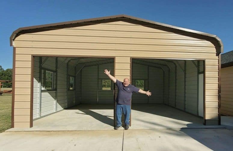 A very happy customer standing in front of a 2-car garage.