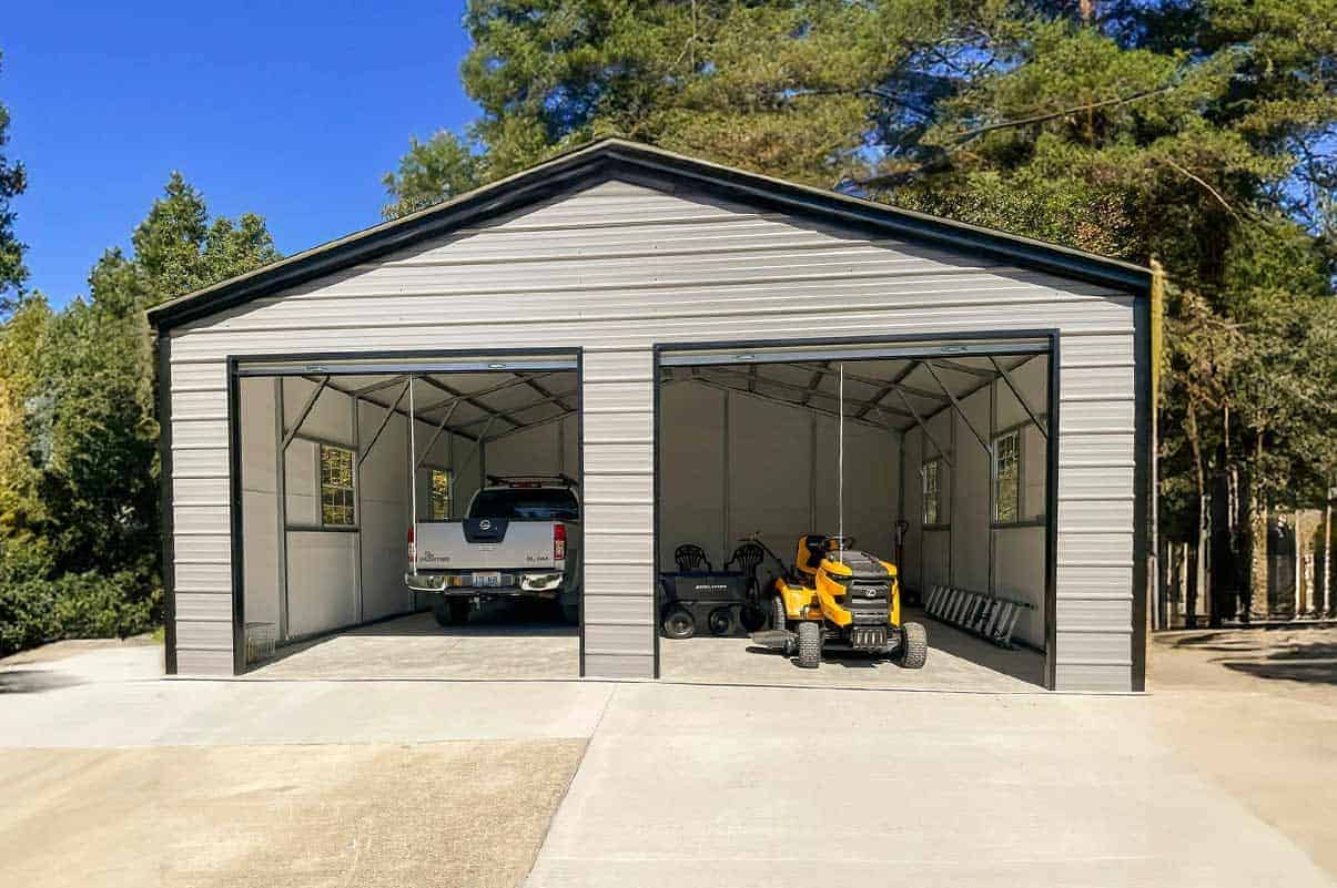 Two-door metal barn with a truck and lawn tractor inside.