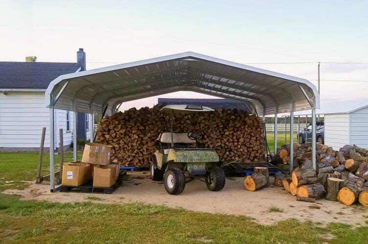 A carport storing firewood and a golf cart.