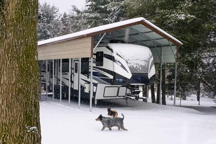 RV carport with side panels. The ground and roof is covered in snow.