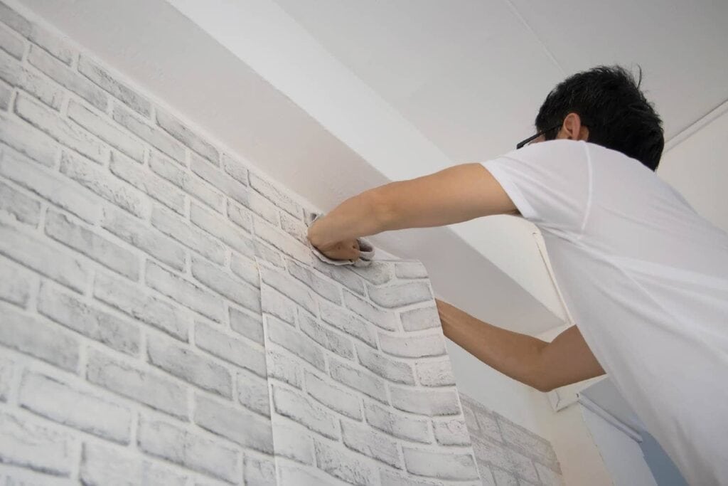 contractor adding peel-and-stick wallpaper to garage wall