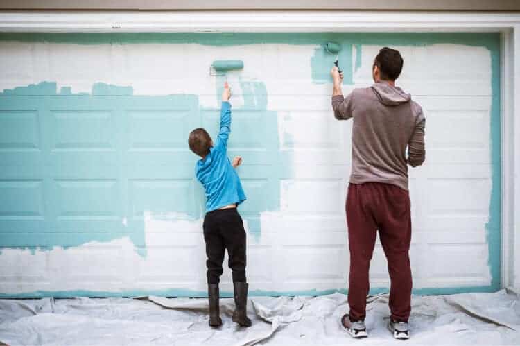 Father and son painting while working on a shed conversion project