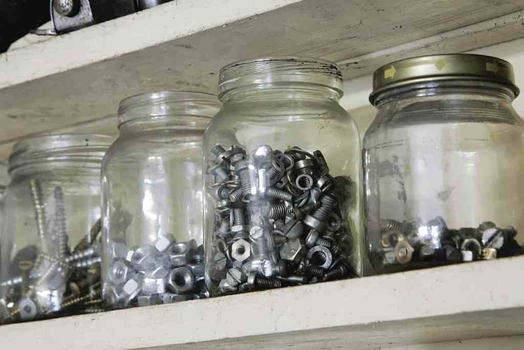 Mason jars storing nails and screws.