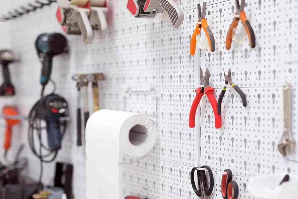 Pegboard with tools hanging on it in an organized garage.