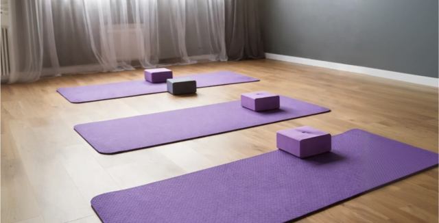 Home gym setup with yoga mats and blocks in a finished metal building space