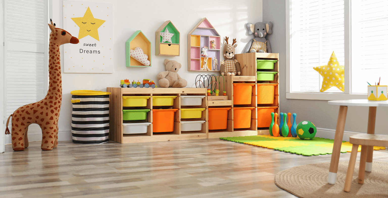 Bright and organized garage conversion children's playroom with colorful toy storage bins, stuffed animals, and foam play mat