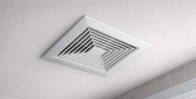 Close-up of a square ceiling air vent installed in a finished room