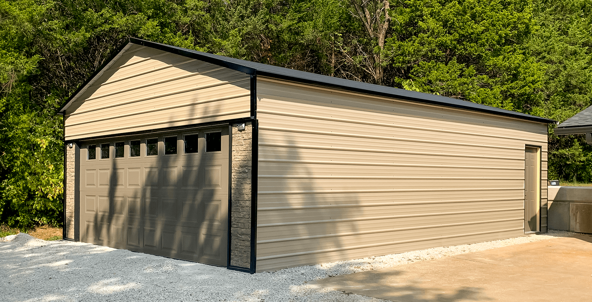 Tan detached metal garage with a brown garage door and side entry