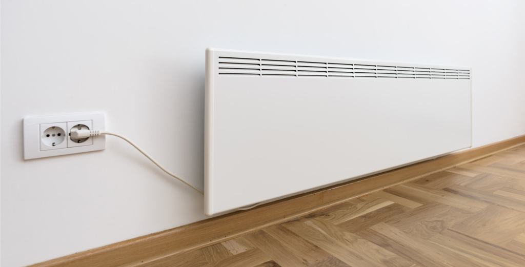 Wall-mounted electric heater plugged into a power outlet