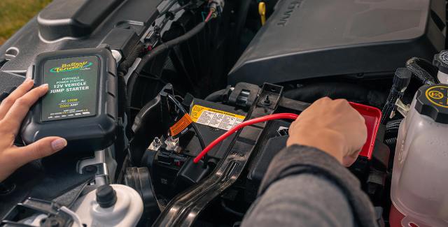 man hooking up a battery tender to a battery